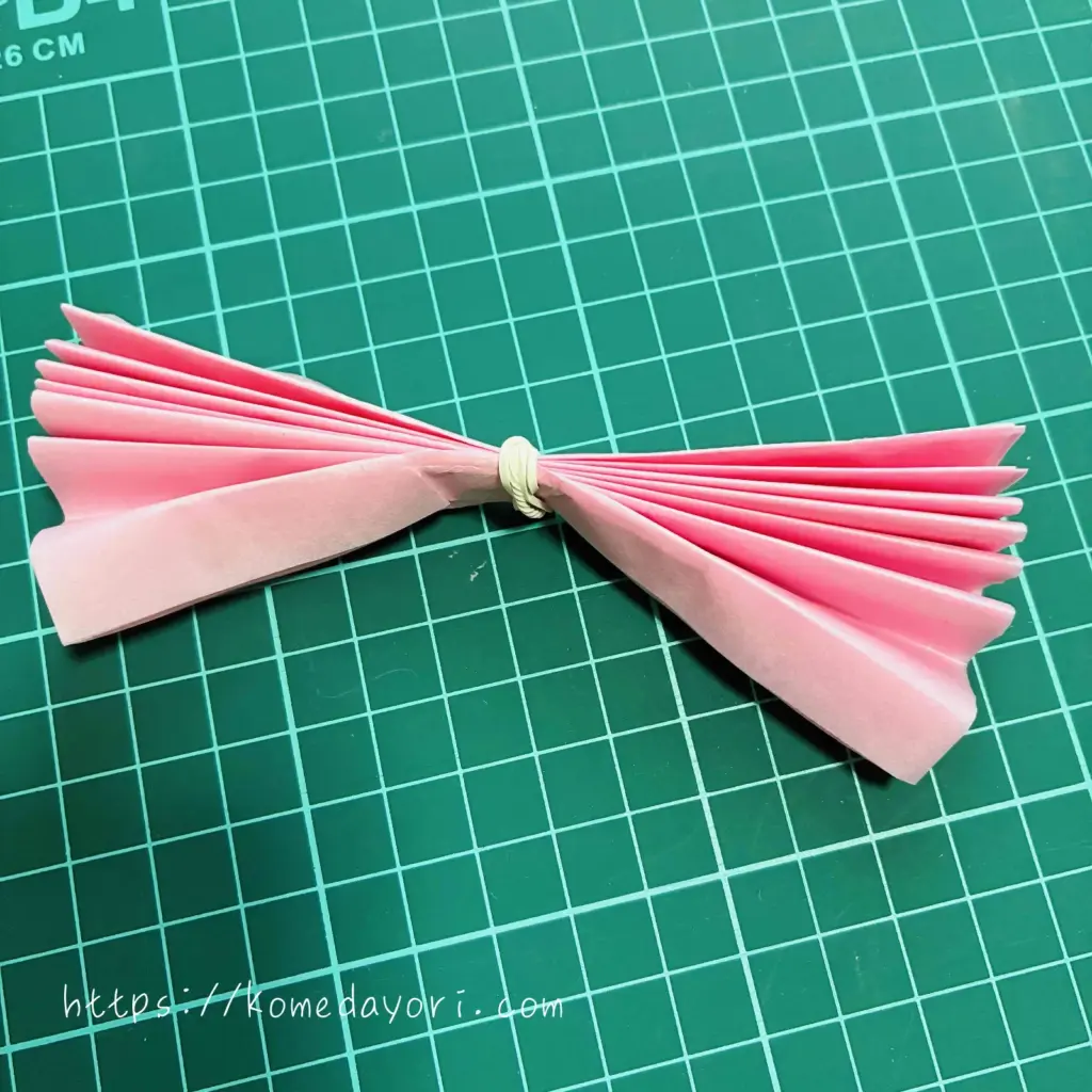 蛇腹折りしたフラワーペーパーを輪ゴムで固定した画像