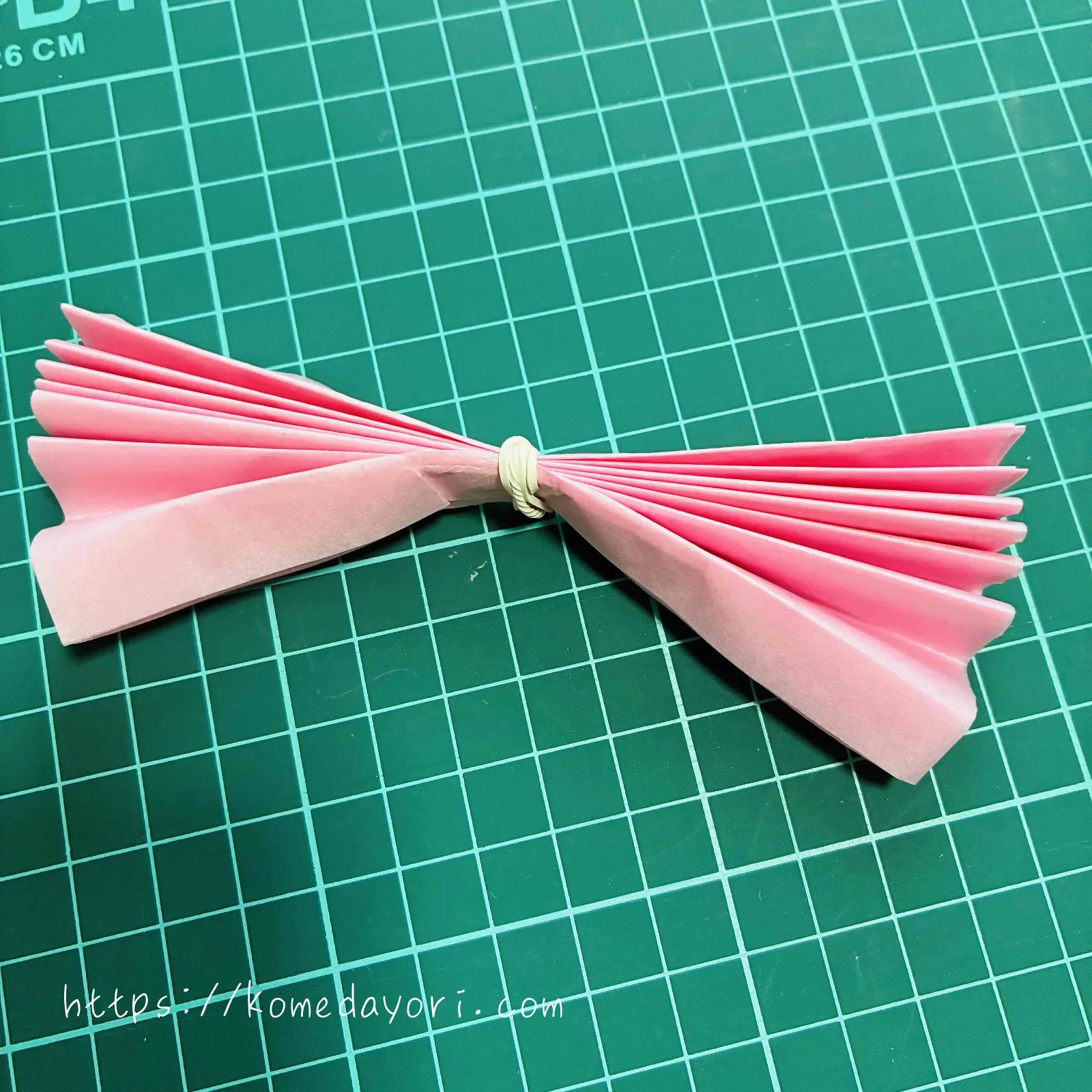 蛇腹折りしたフラワーペーパーを輪ゴムで固定した画像
