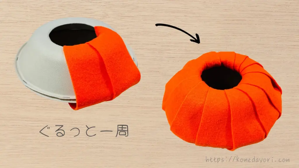 紙ボウルにオレンジのフェルトを帯状に貼り付け、全体を覆ってかぼちゃの形に仕上げている様子