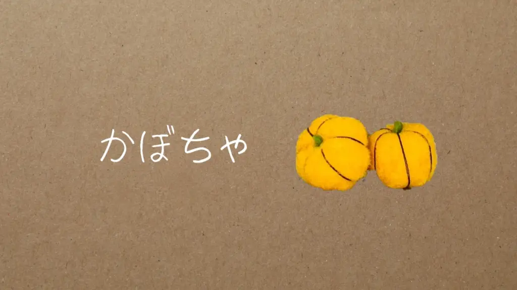 黄色いデコレーションボールで作った手作りかぼちゃのオーナメント。茶色い糸で筋を縫い、緑のヘタをついている。