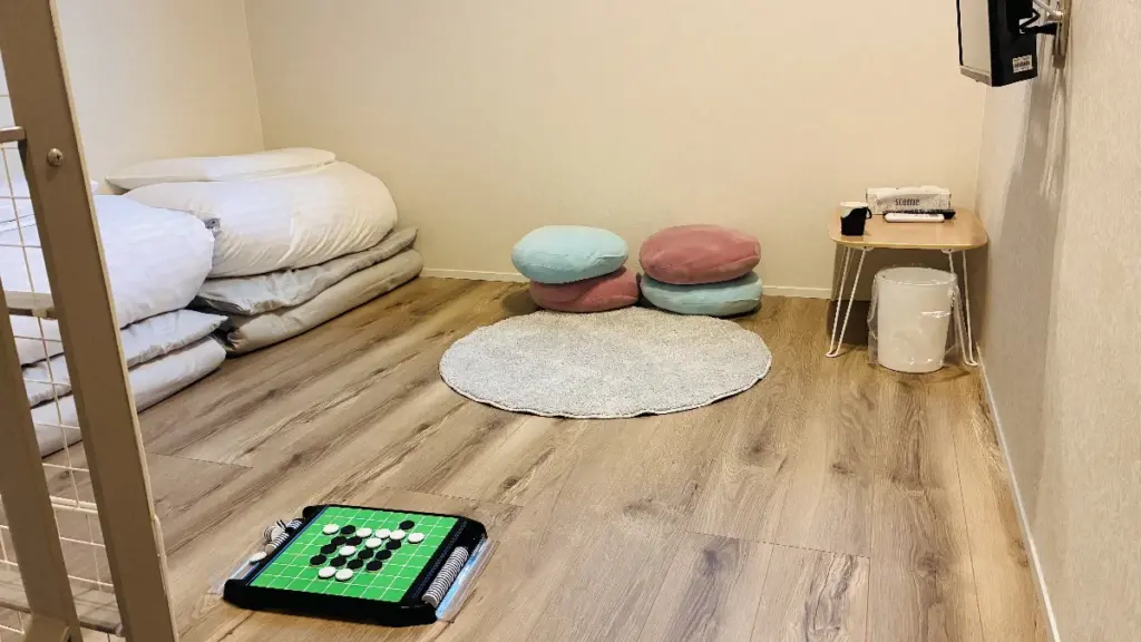 トロールの森ステラのロフトスペース。敷かれた布団と丸いラグ、カラフルなクッション、オセロゲームが置かれている。