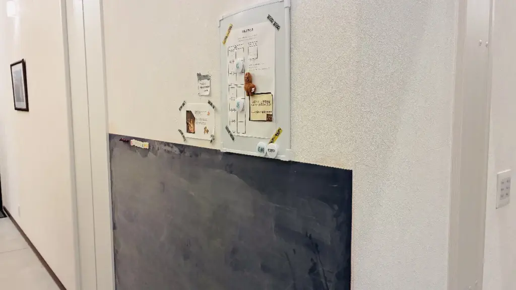 館内の黒板と掲示ボードの写真。黒板はお絵描きでき、上のホワイトボードには案内が掲示されている。