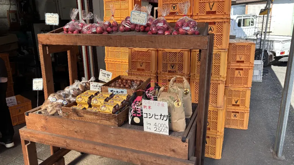 荒巻りんご園の直売所の販売棚。アルプス乙女や新米コシヒカリ、くんせい卵などの商品が陳列されている