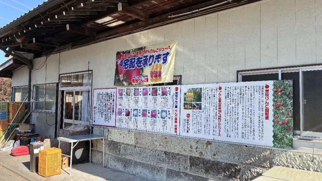 荒巻りんご園の建物前に並ぶ案内パネル。りんごの品種や園の説明が詳しく記載されている