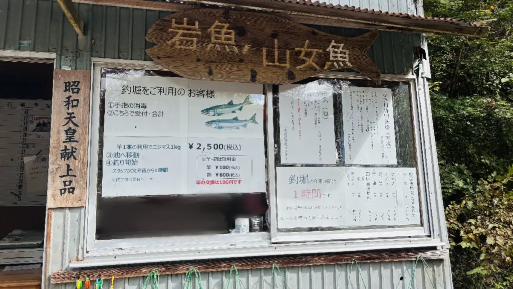一本杉渓流魚センターの受付小屋の正面。料金表や注意書きが掲示されている。