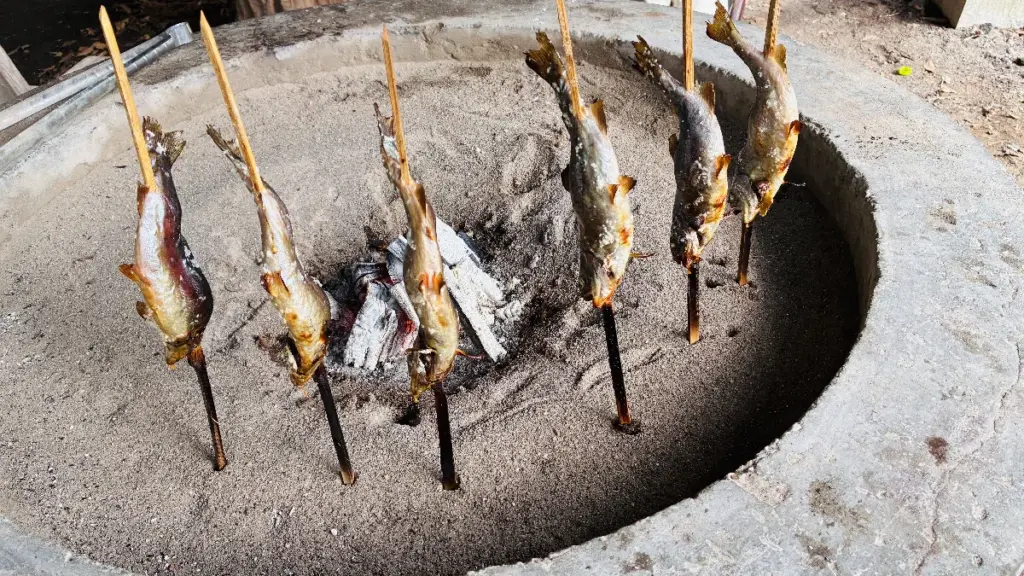 囲炉裏で焼きあがったニジマスが並んでいる写真、脂が落ち食べ頃になるまで待っている状態。