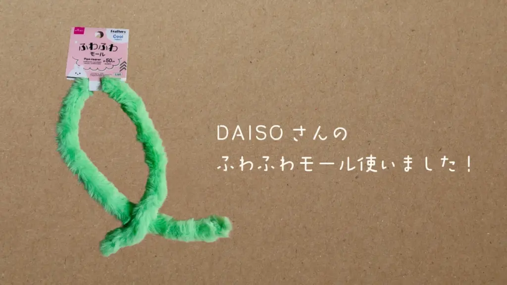 DAISOのふわふわモールのパッケージ写真。緑色のふわふわとした質感のモールが、猫のしっぽのような形で置かれている。「DAISOさんのふわふわモール使いました！」というテキストが表示されている。