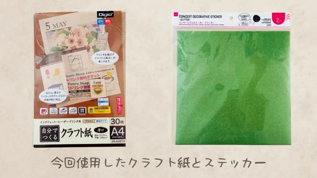 「今回使用したクラフト紙とステッカー」のキャプション付き。左側にA4クラフト紙（ブラウン・厚口タイプ30枚入り）、右側に緑色のコンサートデコステッカー（グリッター）のパッケージ。グリッターはDAISOで購入。