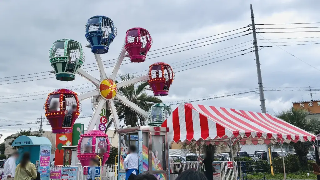 こんにゃくパーク敷地内のミニ観覧車。カラフルなゴンドラが並ぶ子ども向け遊具の写真