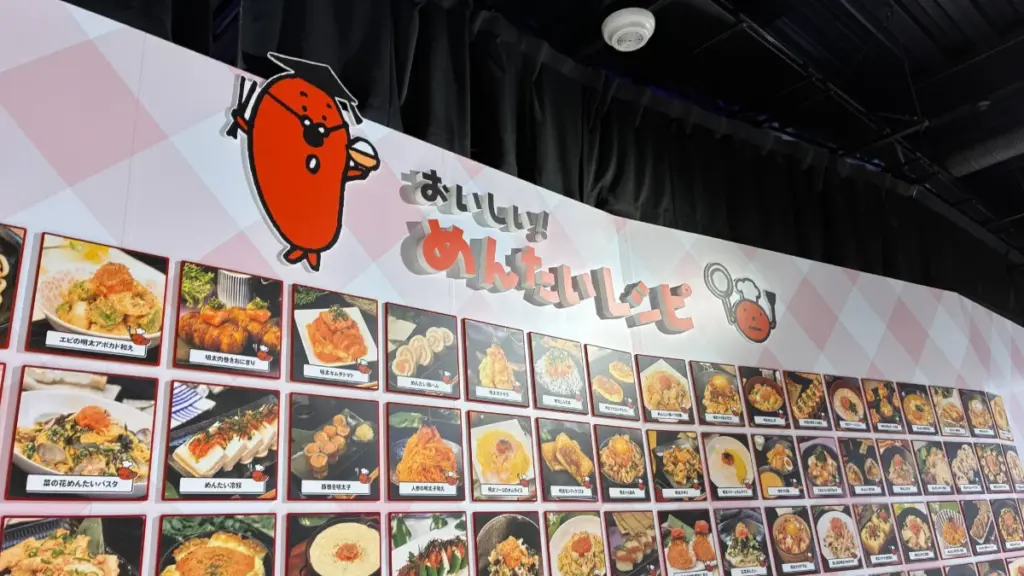 めんたいパーク群馬、つぶつぶランド出口付近の明太子レシピ写真パネル。明太パスタやめんたい卵焼きなど、様々な明太子料理のアイデアが掲示されている