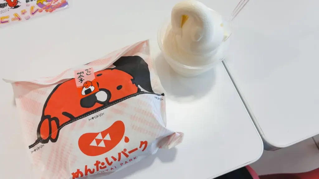 めんたいパークのおにぎりとプレミアム牛乳ソフトクリーム。パッケージにめんたいパークのキャラクターあり