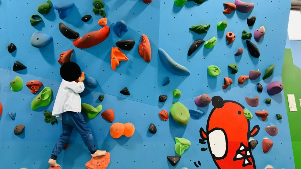 めんたいパーク群馬キッズランド内のボルダリングウォール。子どもが楽しそうに登っている様子