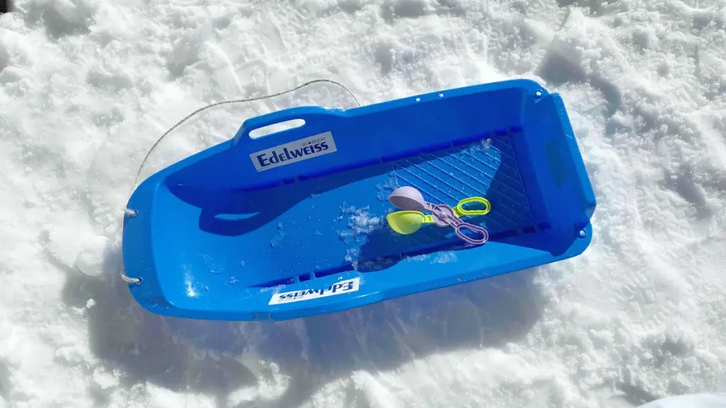 雪の上に置かれた青いレンタルソリと、パステルカラーの雪玉メーカー。