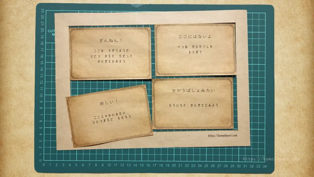 カッティングマット上に印刷された4枚のカットされたはずれカード。異なる内容が記載されている。