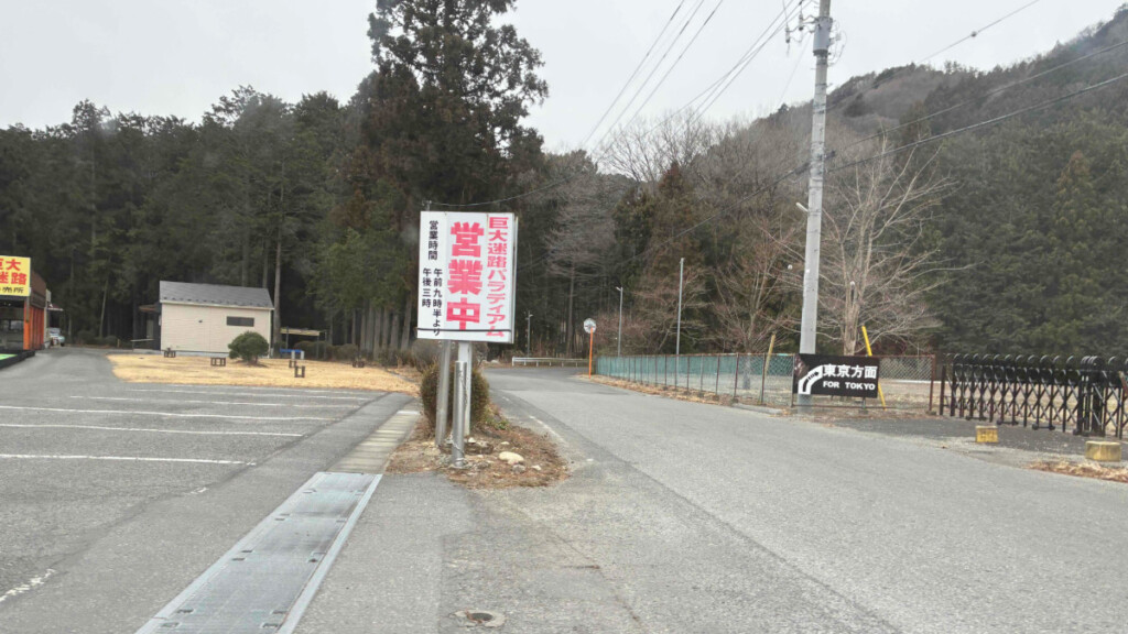 巨大迷路パラディアムの入口案内看板と駐車場付近の道路(栃木県日光市)