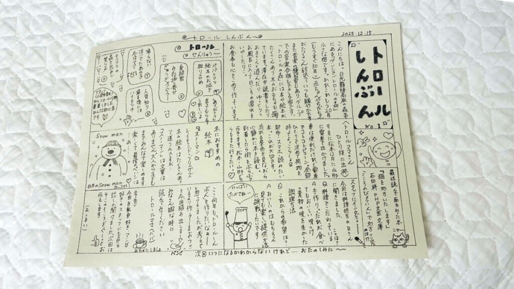 2025年12月15日発行の「トロールしんぶん No.1」と題された手書きのニュースレター。宿の紹介やイラスト、スタッフのインタビュー、冬のおすすめ絵本などが手書きの文字とイラストでびっしりと書かれている。